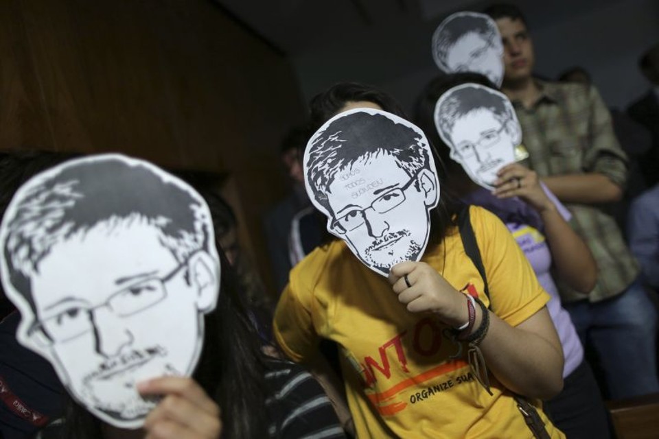 Manifestantes em favor de Edward Snowden usam máscaras do delator no lado de fora do Senado, enquanto, dentro, o jornalista americano Glenn Greenwald prestava depoimento na comissão | Ueslei Marcelino/Reuters