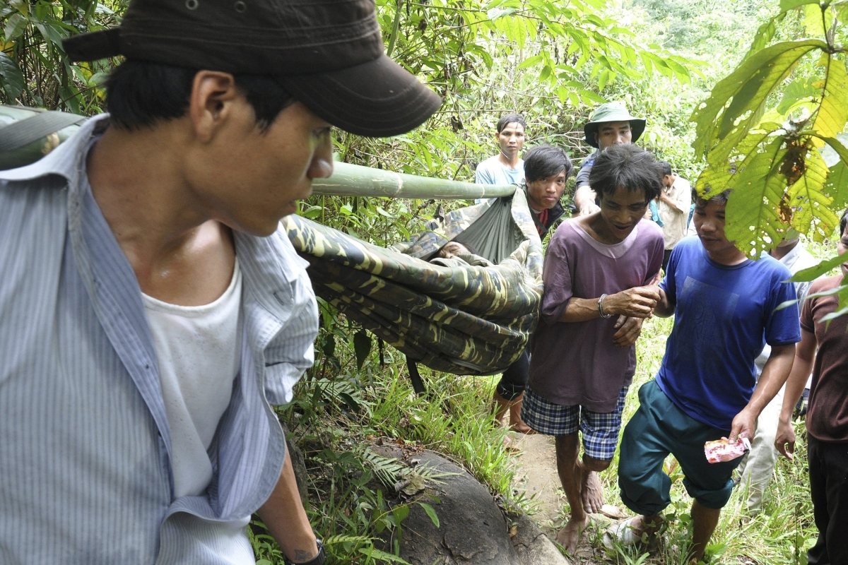 Na quarta-feira, Ho Van Thanh (na maca), agora com 82 anos e frágil demais para andar, foi finalmente transportadode volta à civilização. Seu filho, ao centro de camiseta violeta, acompanhou o pai | EFE/Thanh Nien Online