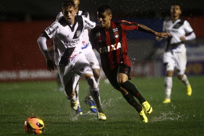 Meia atleticano Everton tenta vencer a marcação e o gramado molhado |