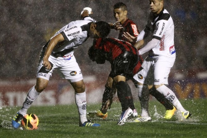 Disputa quádrupla pela bola no encharcado gramado da Vila Capanema |