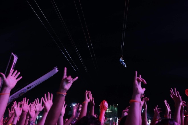 Uma das grandes atrações do festival tem sido a tirolesa por onde os participantes deslizam sob a galera |