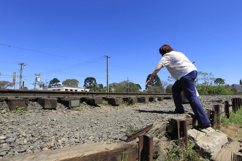 Potencial acidente: senhora sofre para subir os degraus e se arrisca para transpor a ferrovia | Antônio More/ Gazeta do Povo