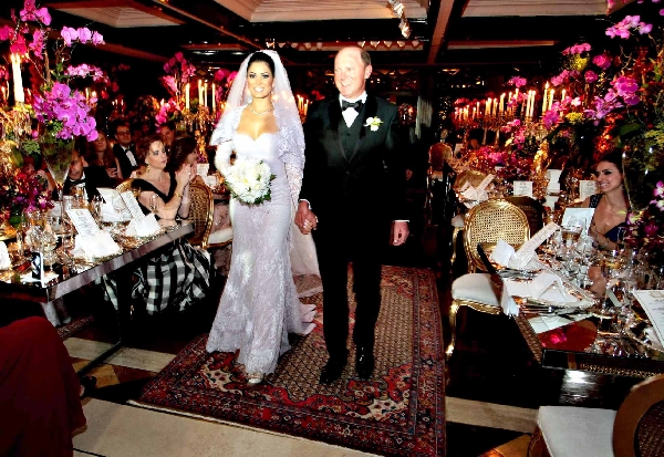 Fernanda Soares e Geninho Thomé se dirigem à cerimônia de seu casamento. Ao lado, uma das elegantes modelos que serviam champagne aos convidados | Jader da Rocha