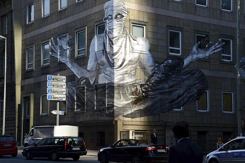 Grafite do artista brasileiro Alexandre Orion na fachada de edifício em Frankfurt, na Alemanha | EFE/Roland Holschneider
