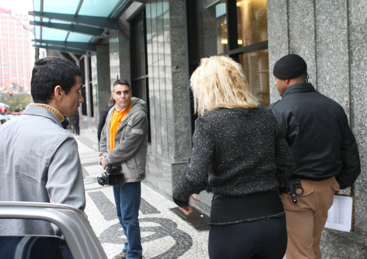 Mulher é escoltada por policiais militares após sair do hotel Bourbon, no Centro de Curitiba | Aniele Nascimento/Agência de Notícias Gazeta do Povo