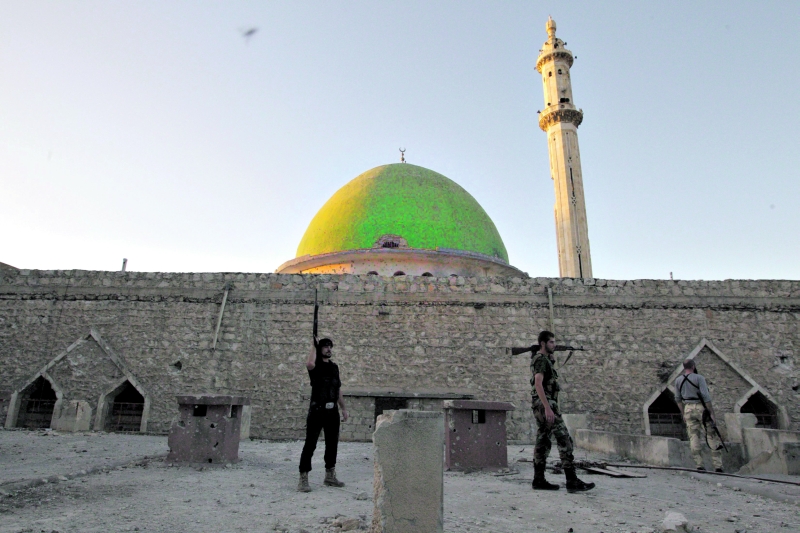 Soldados do Exército Livre da Síria montam guarda ao lado de mesquita destruída em Aleppo | Loubna Mrie/Reuters