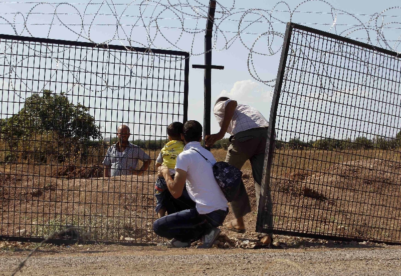 Civis sírios atravessam ilegalmente a fronteira com a Turquia para escapar do conflito entre Bashar Assad e os rebeldes | Molhem Barakat/Reuters