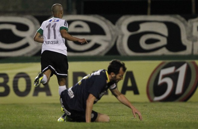 Com o zagueiro santista Edu Dracena no chão, Julio César corre para comemorar seu gol no Couto Pereira | 