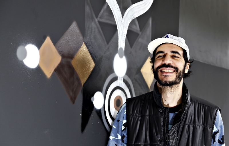 Kboco em frente ao painel na entrada da galeria: diálogo com a arte urbana | Daniel Derevecki/Gazeta do Povo