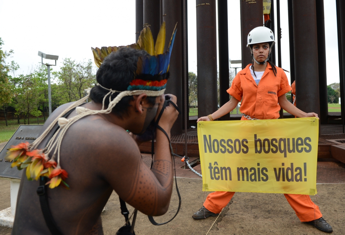 Índio tira foto de ativista do Greenpeace durante protesto | Agência Brasil/Antonio Cruz