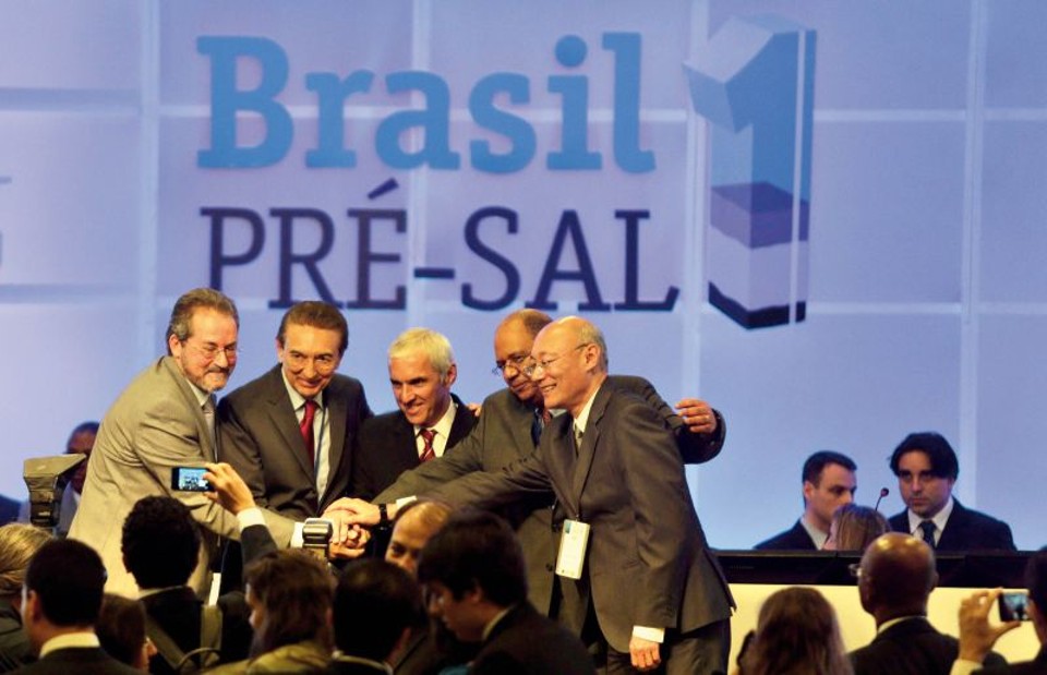 O ministro das Minas e Energia, Edison Lobão, com representantes do consórcio, após o leilão | Ricardo Moraes/ Reuters
