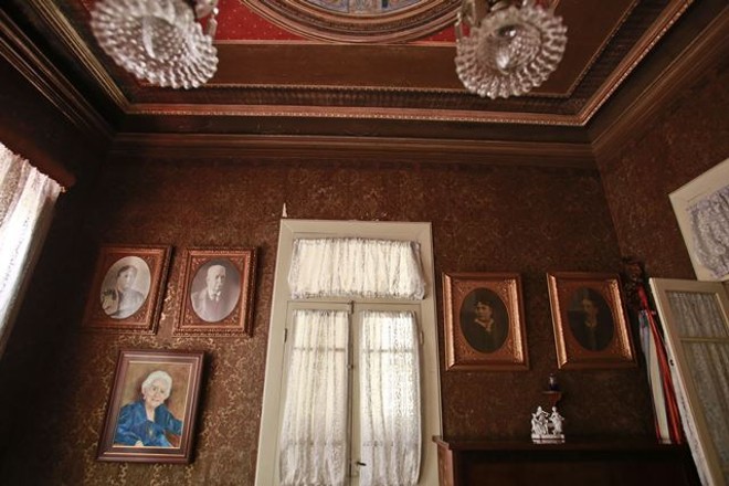 Na sala de estar, quadros de familiares e amigos ocupam as paredes |