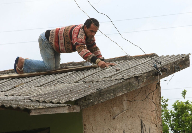 Morador do bairro Campo do Santana, em Curitiba, repara estragos provocados por granizo. Capital foi cidade que mais teve casas danificadas | Aniele Nascimento/Gazeta do Povo