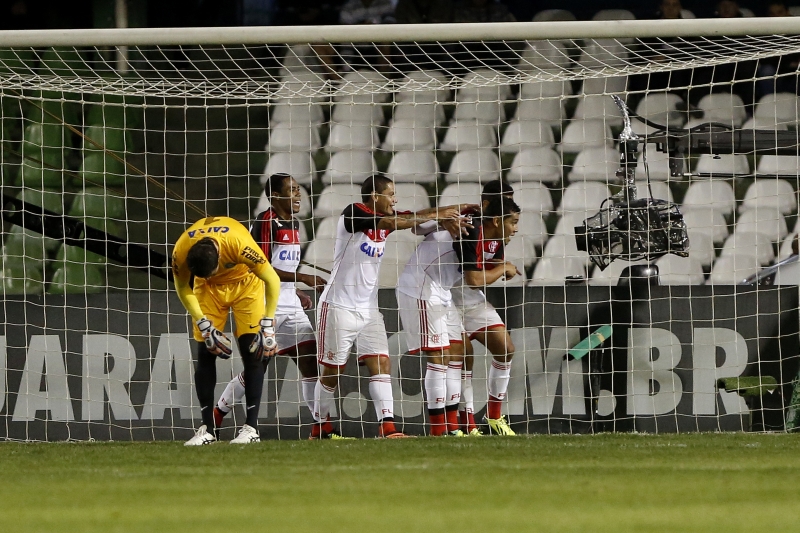 Enquanto o goleiro Vanderlei arruma o meião, desolado, os jogadores do Flamengo fazem trenzinho diante da câmera na comemoração do gol contra o Coritiba, no Couto Pereira | Marcelo Andrade/ Gazeta do Povo
