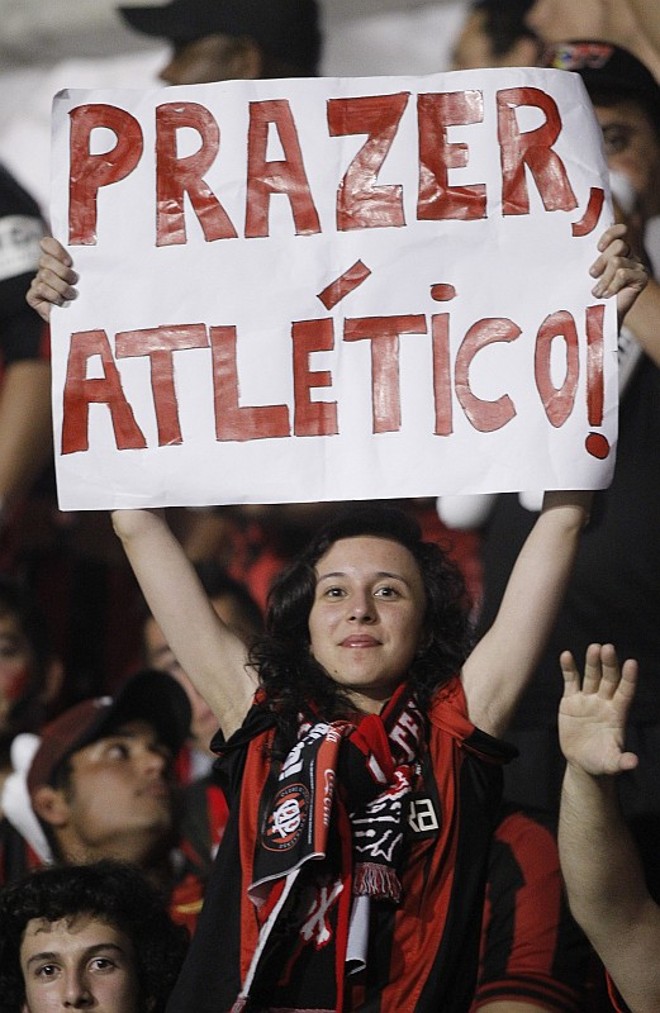 Torcedora levanta cartaz apresentando time atleticano para o Brasil |