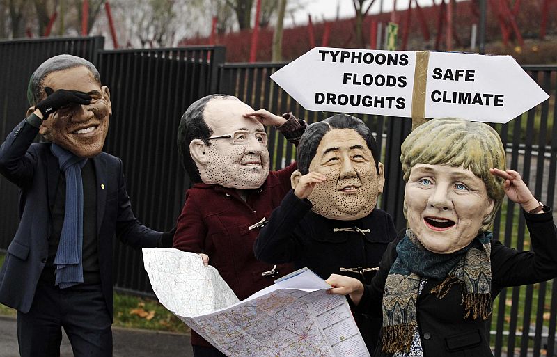 Manifestantes usam máscaras dos presidentes dos EUA (Barack Obama), da França (Francois Hollande), Japão (primeiro-ministro Shinzo Abe) e da Alemanha (chanceler Angela Merkel) durante a Conferência do Clima em Varsóvia | REUTERS/Kacper Pempel