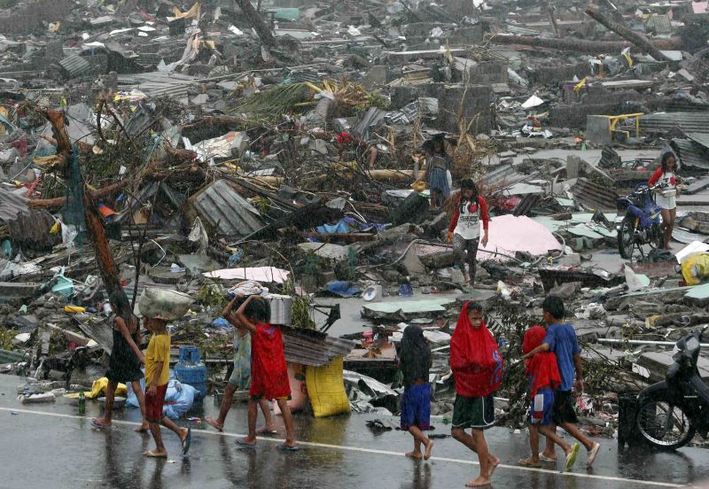 Sobreviventes carregam seus pertences em meio a casas destruídas pelo Tufão Haiyan, que deixou mais de 10 mil mortos nas Filipinas | REUTERS/Erik De Castro