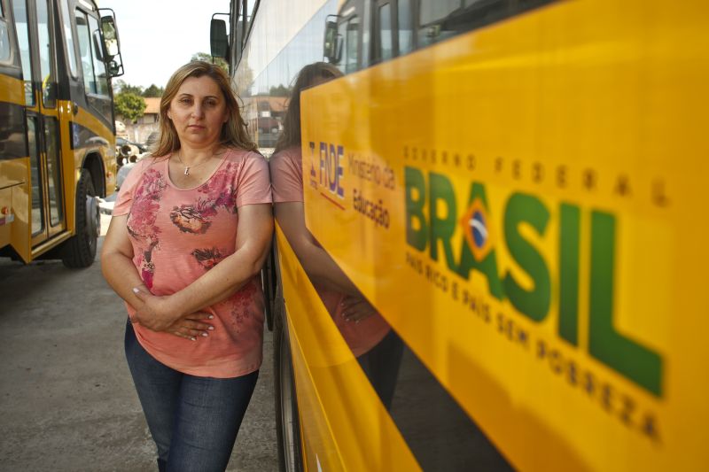 A secretária municipal de Educação de Piraquara, Loireci Dalmolim, ao lado de um ônibus comprado com verba do governo federal: prefeitura assume o pagamento dos motoristas | Marcelo Andrade / Gazeta do Povo