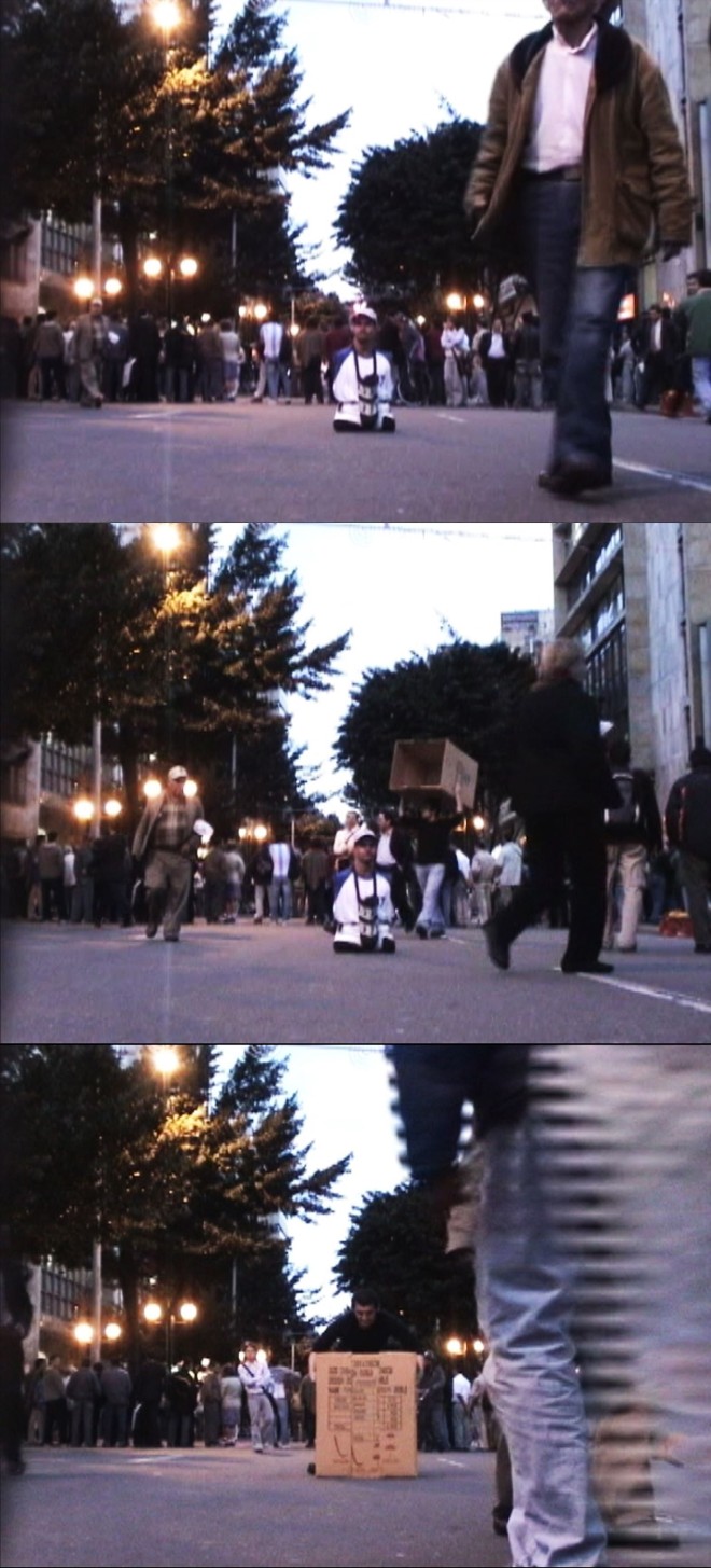 Ejercicio de Anulación, Edwin Sanchez: Uma arte política e contestadora, que evidencia os aspectos mais perversos da sociedade é a base dos trabalhos do artista colombiano, cujas obras estão expostas no Solar do Barão. No vídeo Ejercicio de Anulación, o artista coloca uma caixa de papelão sobre um deficiente físico sem os braços e as pernas, que mendiga nas ruas, sem que ele saiba. O ato mostra a condição de vulnerabilidade social, e chama atenção para a condição do indigente | 