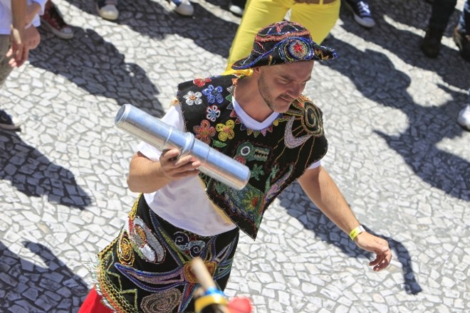 Com roupas coloridas, chocalhos e bandeiras, o grupo animou o público na passagem pela Rua XV | 