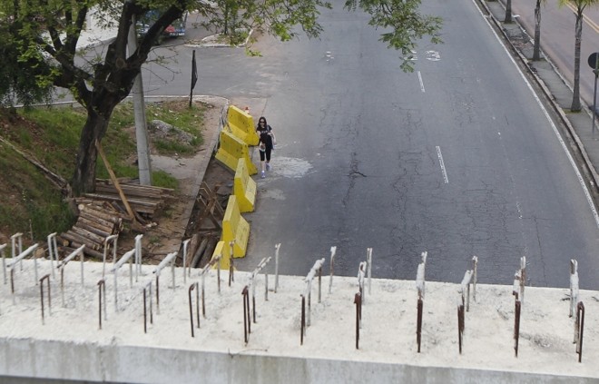 Pedestre precisa desviar de obra caminhando pela rua | 