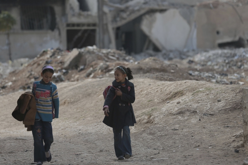 Estudantes caminham na periferia de Damasco: ir à escola no país se tornou um desafio | Bassam Khabieh/Reuters
