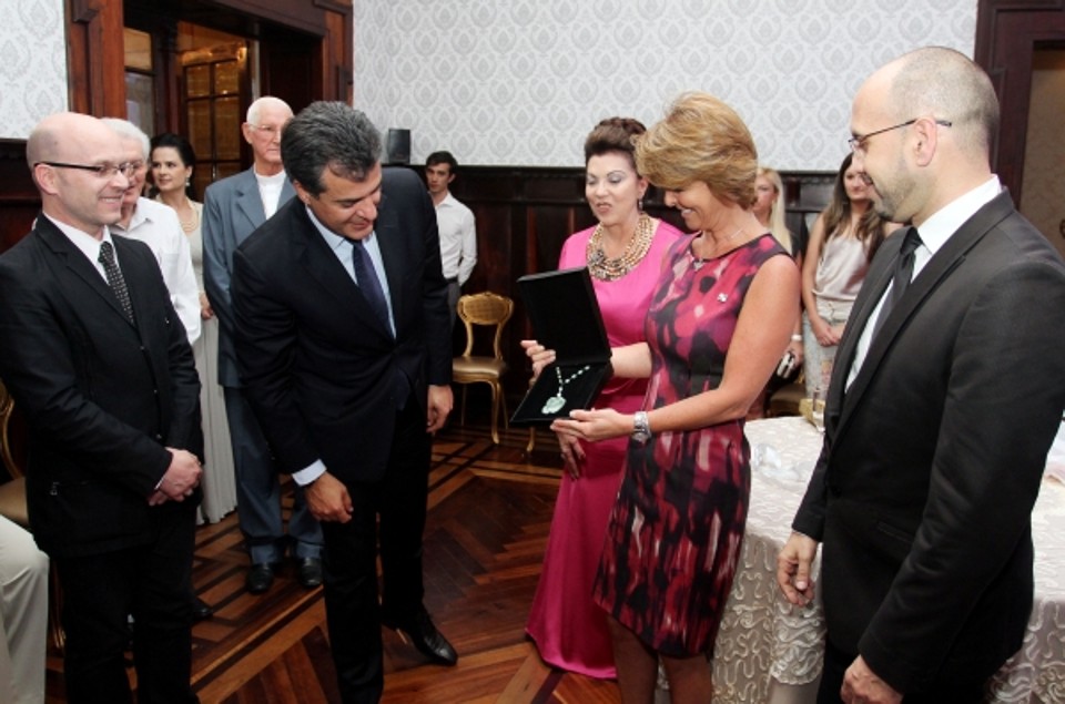 Fernanda Richa e o governador Beto Richa conferem a joia que ela ganhou de Vera Lupion (ao fundo) na festa de abertura da nona edição do Natal Encantado, anteontem, no Castelo do Batel. A peça, confeccionada pelos irmãos e designers Marcelo (à esq.) e Rodrigo Alarcon, é um colar de jade, seda e pérolas | Rogério Machado