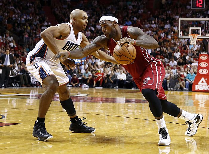 LeBron James passa pela marcação de Gerald Henderson na vitória do Miami Heat sobre o Charlotte Bobcats | Robert Mayer / Reuters