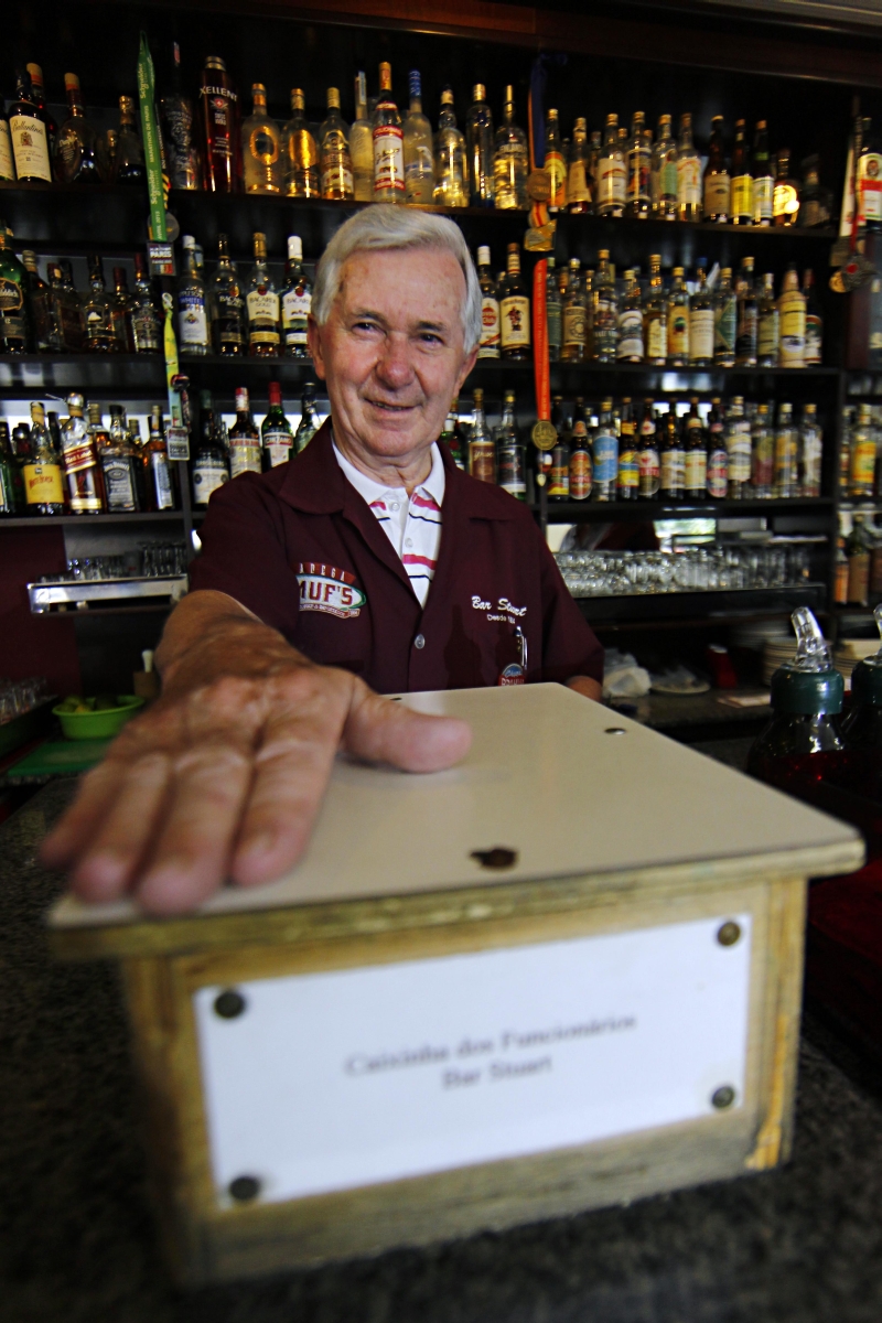 Dino Chiumento, garçom do Bar Stuart desde 1950, conta que a caixinha fica no balcão o ano todo e é aberta em janeiro | Albari Rosa/ Gazeta do Povo