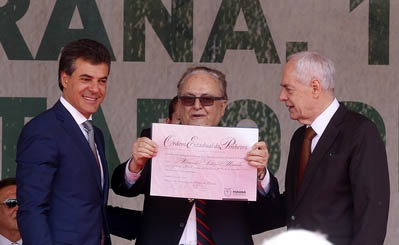 Fernando Miranda, ladeado pelo governador Beto Richa e Reinhold Stephanes, chefe da Casa Civil do Palácio Iguaçu, exibe a Ordem do Pinheiro | Arnaldo Alves/AEN