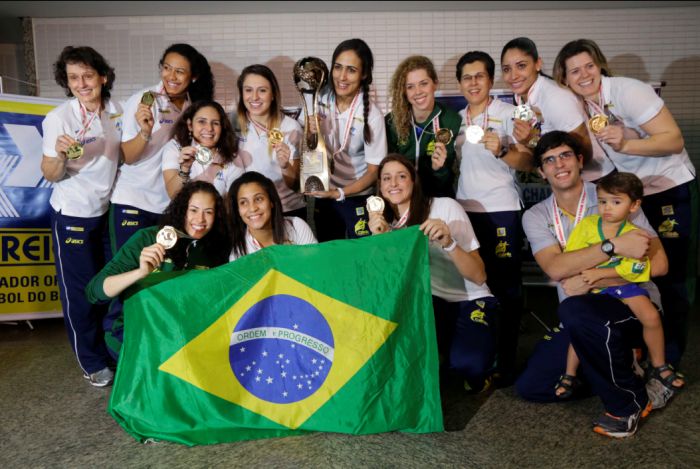 Jogadoras da seleção de handebol com o troféu de campeã mundial no desembarque em São Pauo | Nelson Antoine / Folhapress