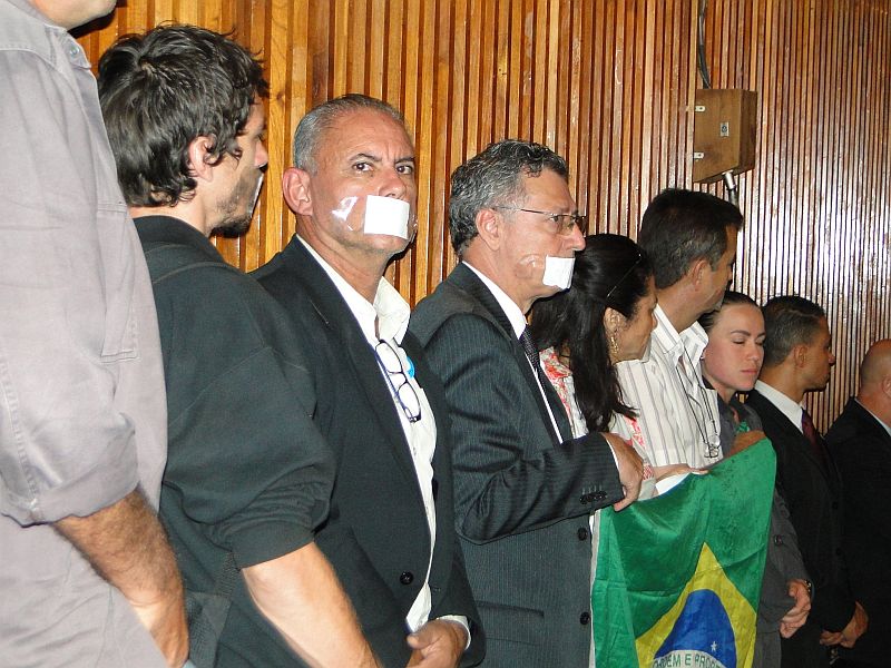 Manifestantes que acompanhadm audiências da CPI colaram adesivos na boca em protesto por não poderem se manifestar. Seguranças da Assembleia os tiraram da sessão com força | Divulgação / Deputado Nelson Luersen
