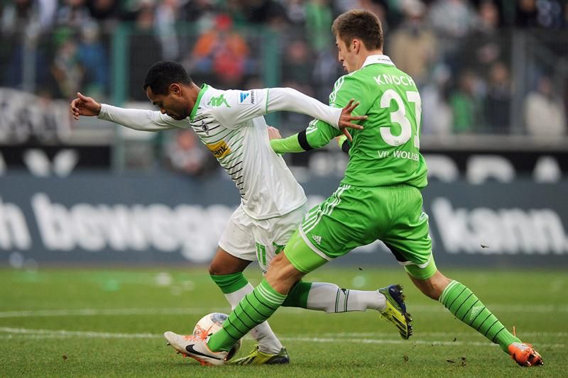 Autor de um dos gols do time da casa, brasileiro Raffael tenta escapar da marcação de Knoche, do Wolfsburg | Marius Becker / EFE