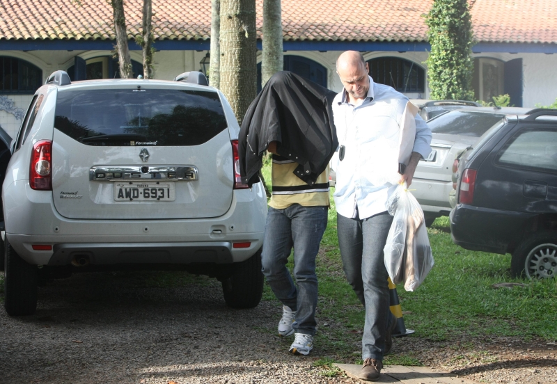 Agente do Gaeco conduz um dos suspeitos detidos ontem, em Curitiba: investigação começou após a invasão de um casarão que funcionava como cassino no bairro Parolin | Aniele Nascimento/Gazeta do Povo