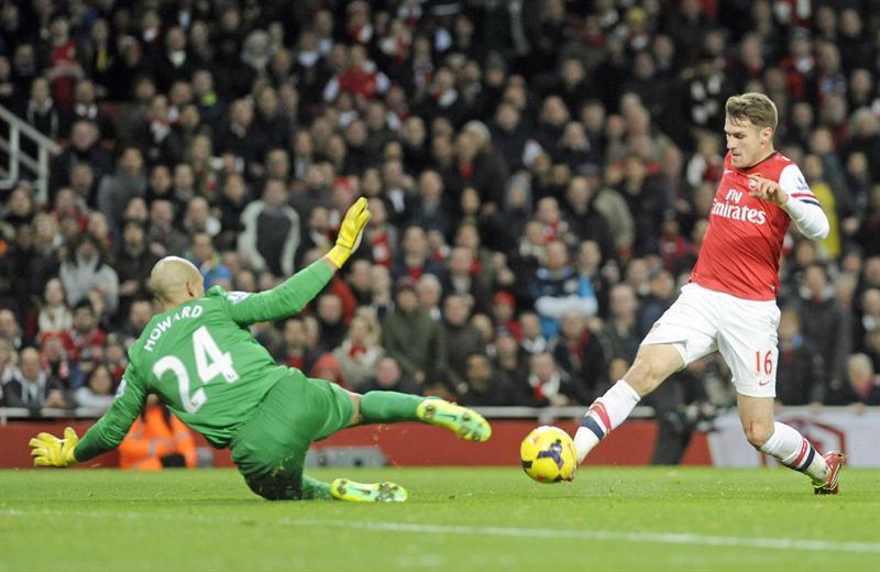 Aaron Ramsey (à direita), do arsenal, disputa a bola com o goleiro Tim Howard, do Everton, em partida pelo campeonato inglês | EFE/EPA/GERRY PENNY