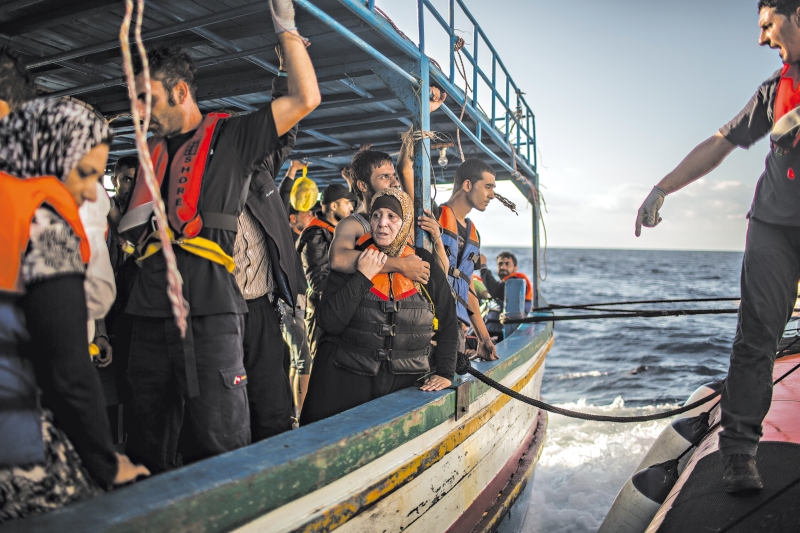 Sírios fogem da guerra passando pela Itália, na esperança de chegar a países mais prósperos; acima, resgate feito por italianos | Bryan Denton para The New York Times