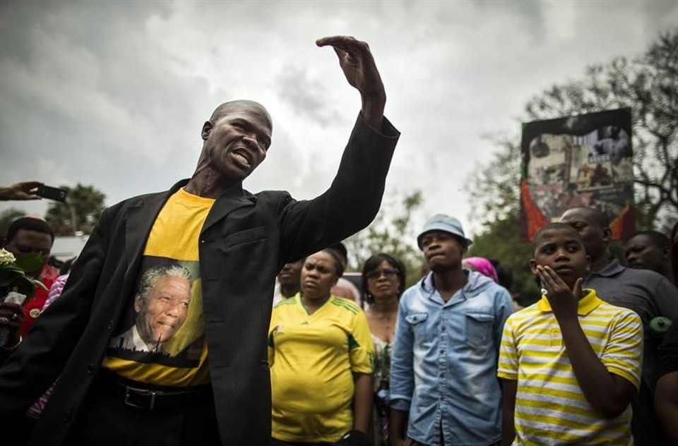 Homem lidera grupo de orações por Mandela, neste domingo na África do Sul | EFE/EPA/IAN LANGSDON