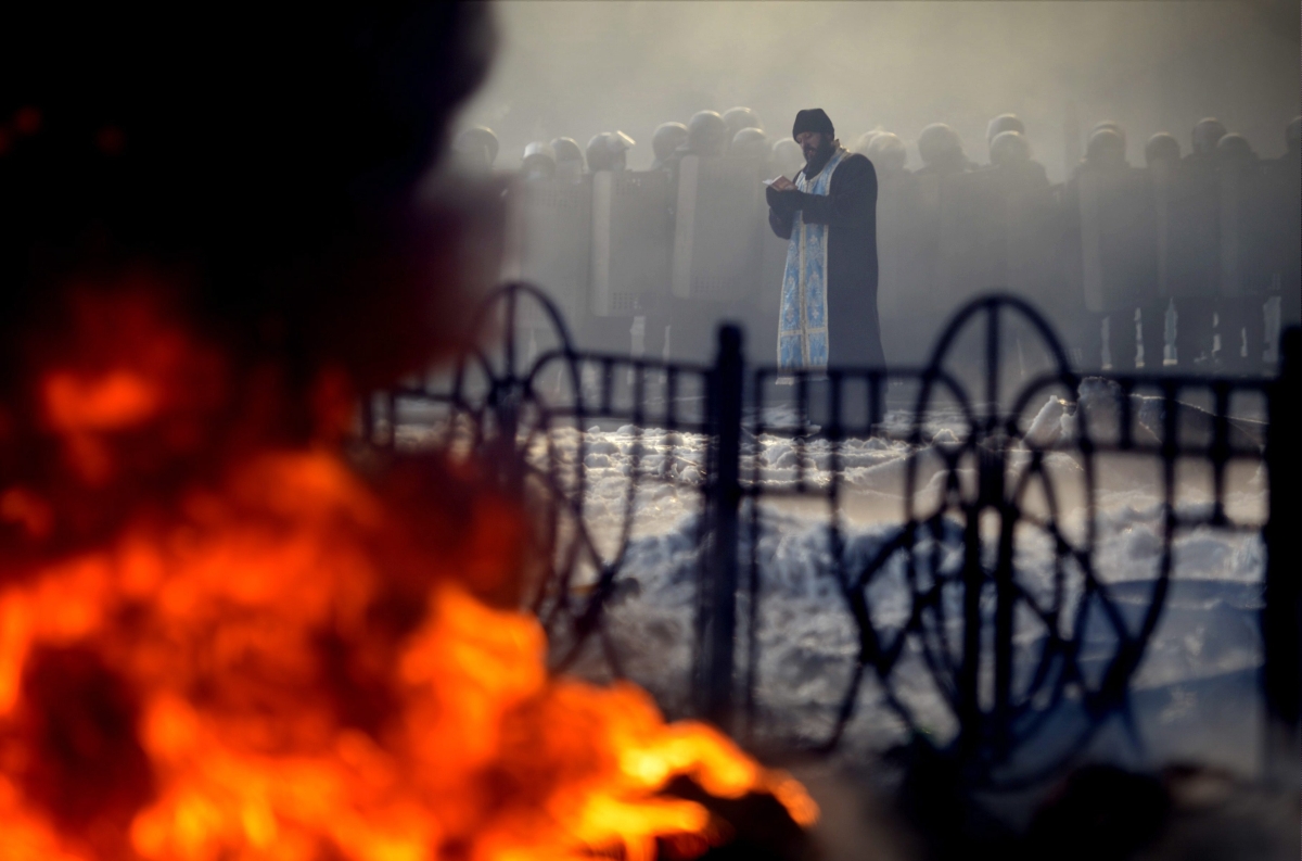 Padre ortodoxo faz oração próximo de barricadas dos manifestantes em Kiev, na Ucrânia | Reuters/Antti Aimo-Koivisto, Lehtikuva
