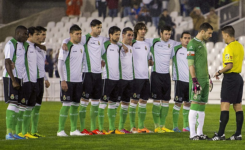 Jogadores do Racing Santander se abraçam no centro do gramado enquanto o capitão da equipe comunica que o time estava abandonando a partida | Esteban Cobo / EFE