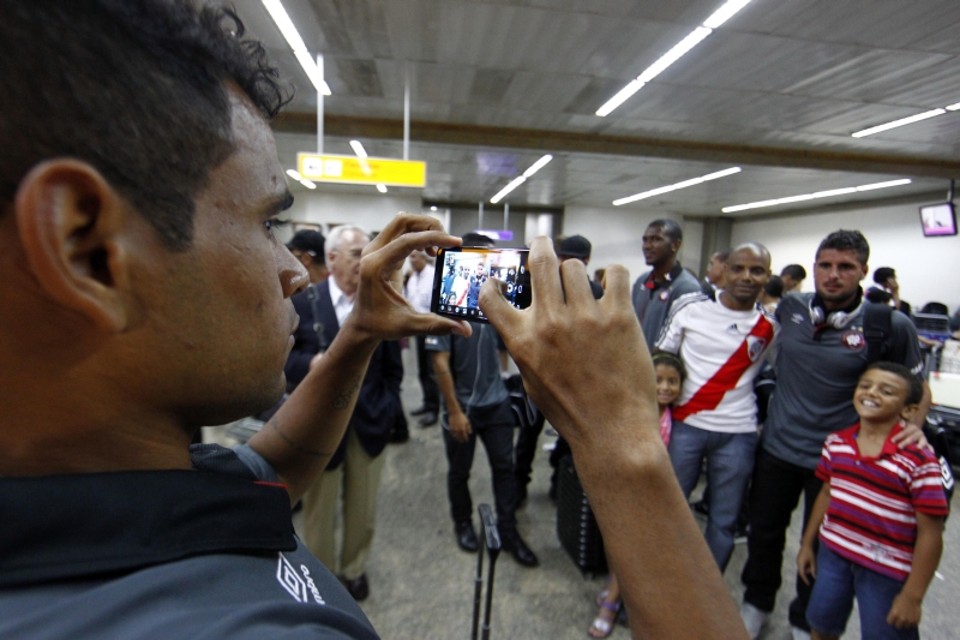 Atacante Éderson dá uma de fotógrafo ao registrar o companheiro Mérida posando com fãs no aeroporto de Guarulhos, em São Paulo | Albari Rosa, enviado especial/ Gazeta do Povo
