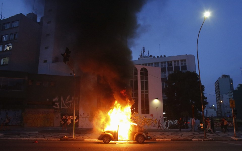 Carro é incendiado durante os protestos de sábado (25) na capital paulista | Reuters/Nacho Doce