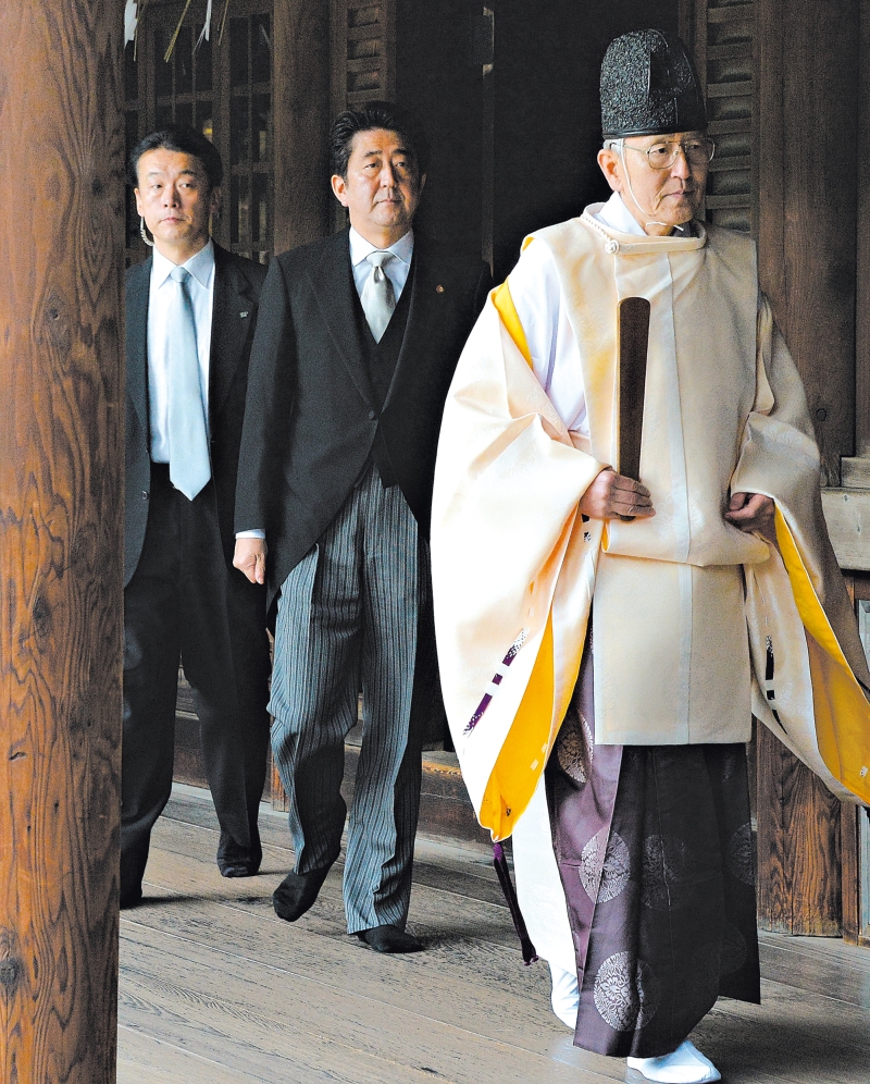 O primeiro ministro japonês Shinzo Abe, ao centro, no Templo de Yasukuni, visita que está causando tensão na Ásia | Toru Ya Manaka/Agence France Presse Getty Images
