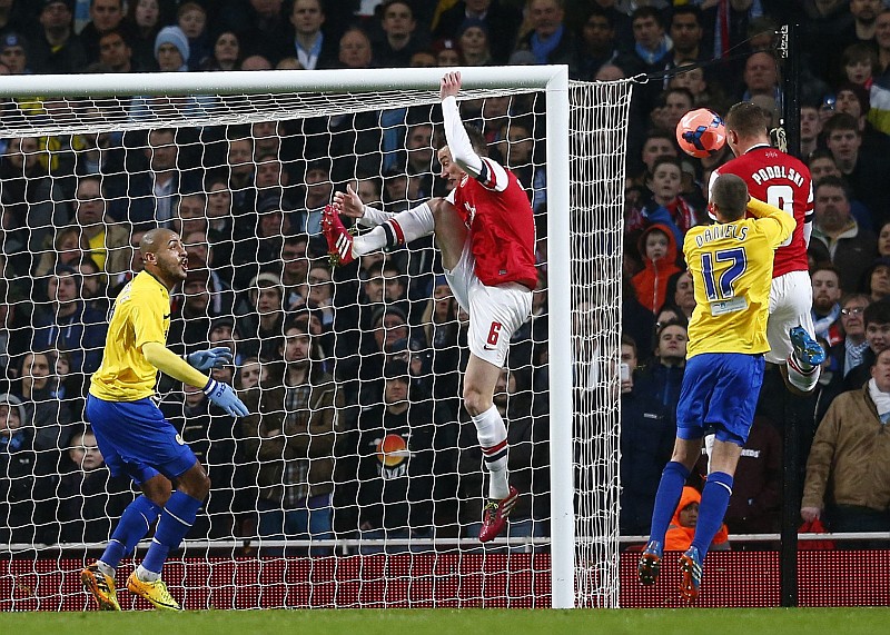 Podolski cabeceia para marcar o primeiro gol da vitória do Arsenal sobre o Coventry | Andrew Winning / Reuters