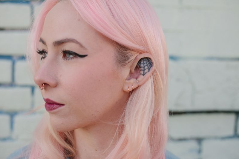 Keely Kuykendall tatuou uma teia de aranha; limites da orelha geralmente pedem um desenho simples, mas algumas pessoas fazem escolhas ousadas | Ilana Panich-Linsman para The New York Times