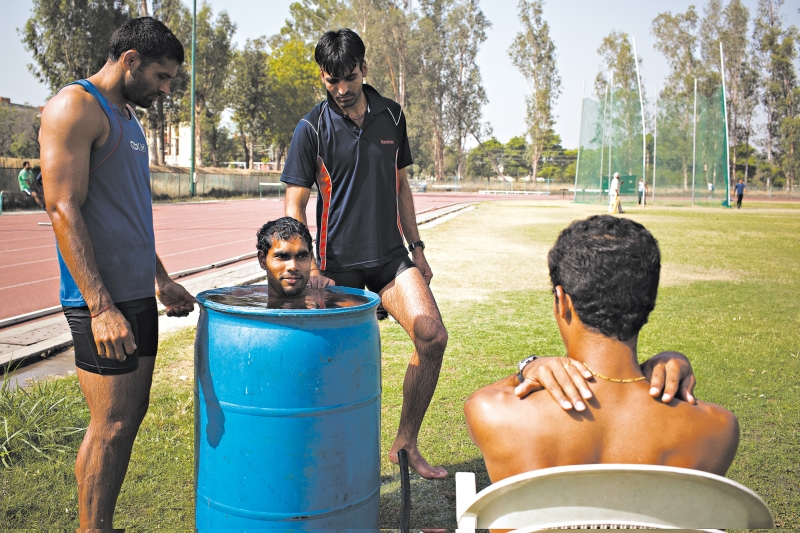 A Índia não tem centros de treinamento modernos. Atleta usa um barril de água gelada para se refrescar | Enrico Fabian para The New York Times