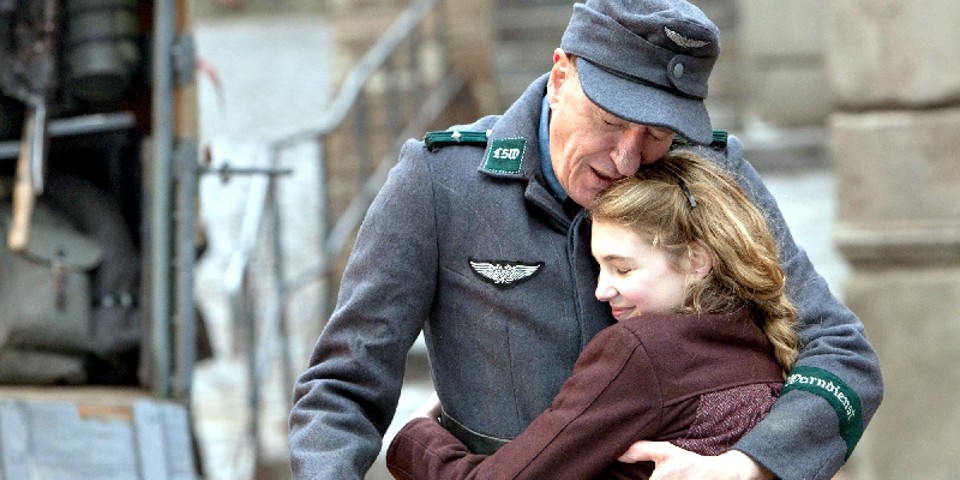 Geoffrey Rush vive o pai adotivo da menina Liesel, que busca consolo na leitura em meio à guerra | Divulgação