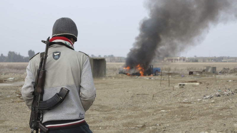 Militante sunita observa carro de polícia incendiado na cidade de Ramadi, tomada por grupo ligado à Al-Qaeda | Ali al-Mashhadani/Reuters