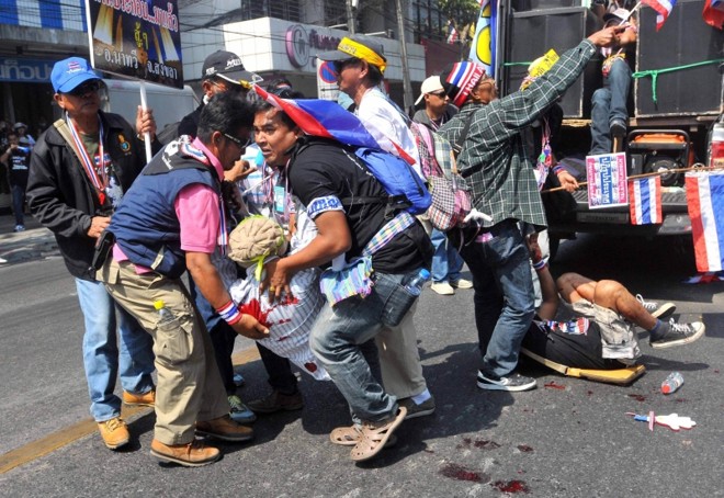 Manifestantes socorrem colega ferido por explosão | Stringer/Reuters