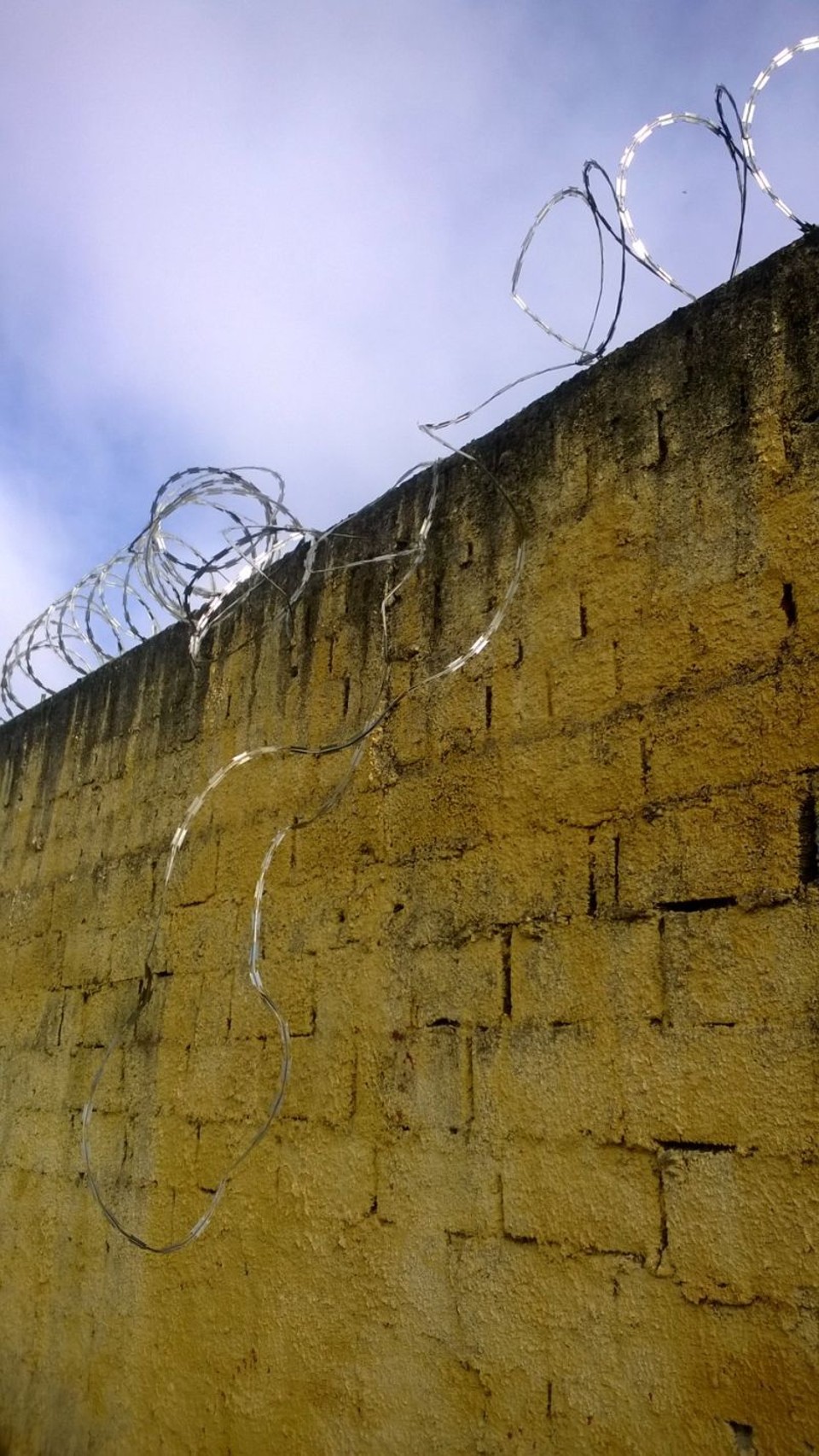 Após fugir em buraco feito na galeria, presos pularam muro protegido por arame farpado, que está danificado | Aniele Nascimento/ Agência de Notícias Gazeta do Povo