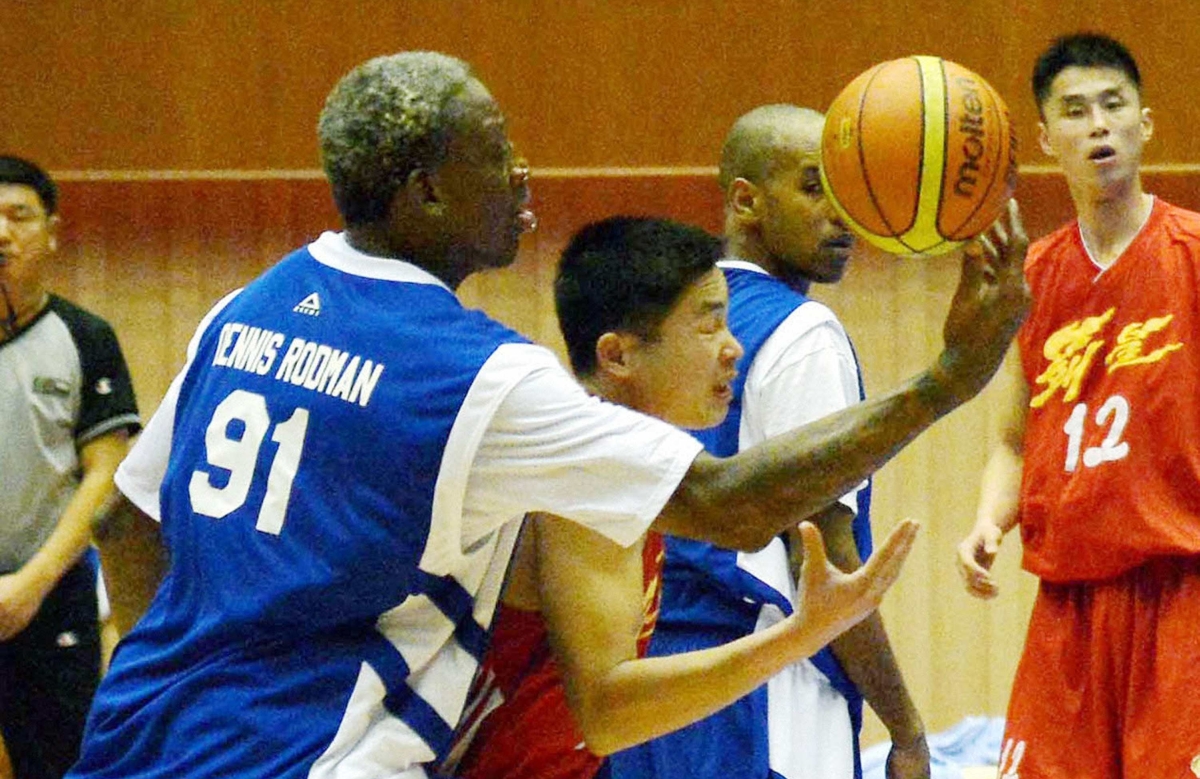 Dennis Rodman disputa a bola durante o jogo-homenagem ao líder norte-coreano Kim Jong-un | Reuters/Kyodo
